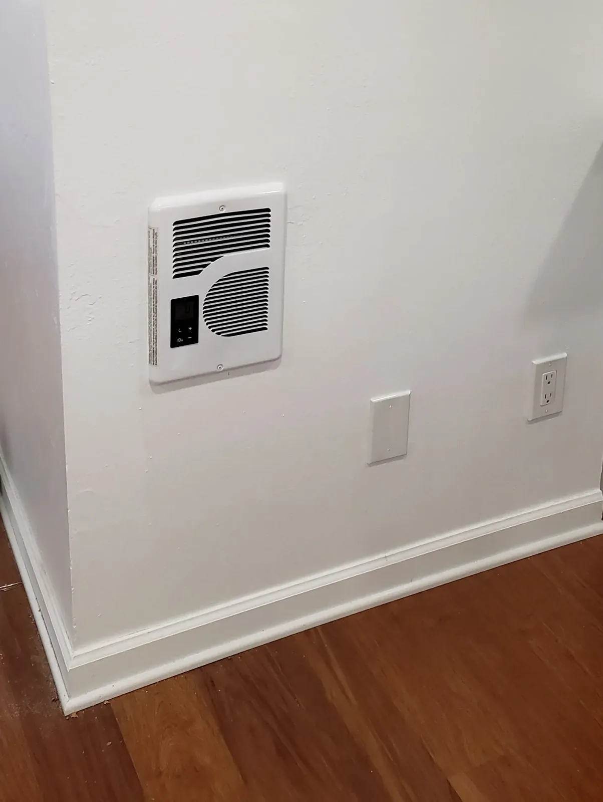Electric wall heater and receptacle installation in a finished interior room